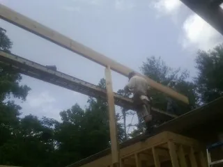 Carpenter setting a ridge beam over a new addition frame — Ice Dam Removal by Roofing Brothers in Etters