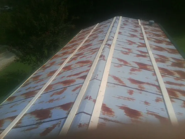 Rusted metal roof panels with new wood purlins before replacement — Storm Damage Roof Repair in Etters by Roofing Brothers
