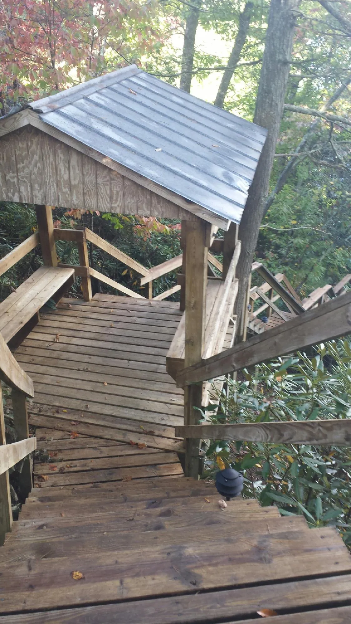 Metal roofed shelter over wooden steps on a wooded walkway — Skylight Repair & Installation work by our crew in Etters