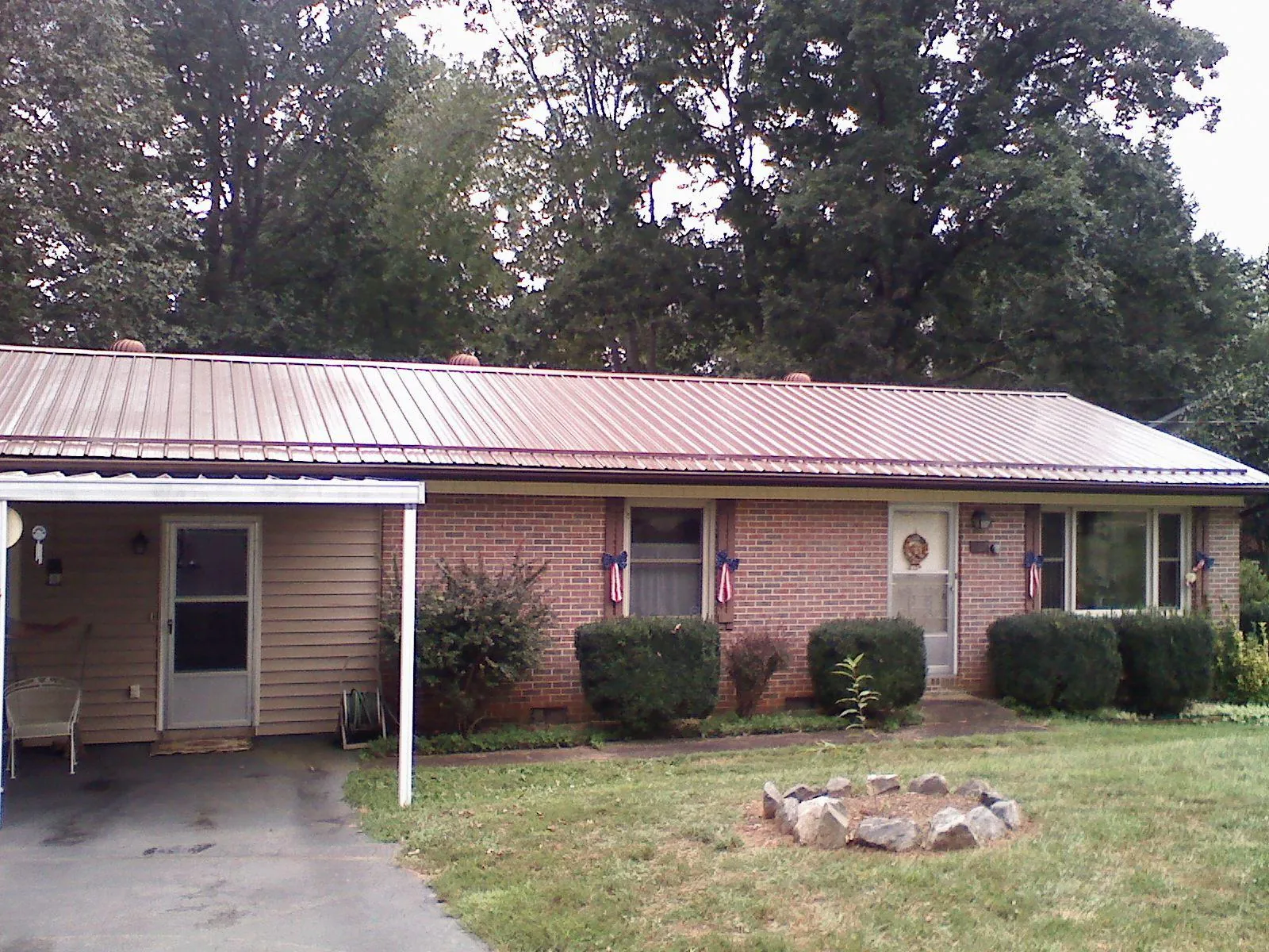 Bronze metal roof and carport on a brick ranch home — Roof Repair work by our crew in Etters