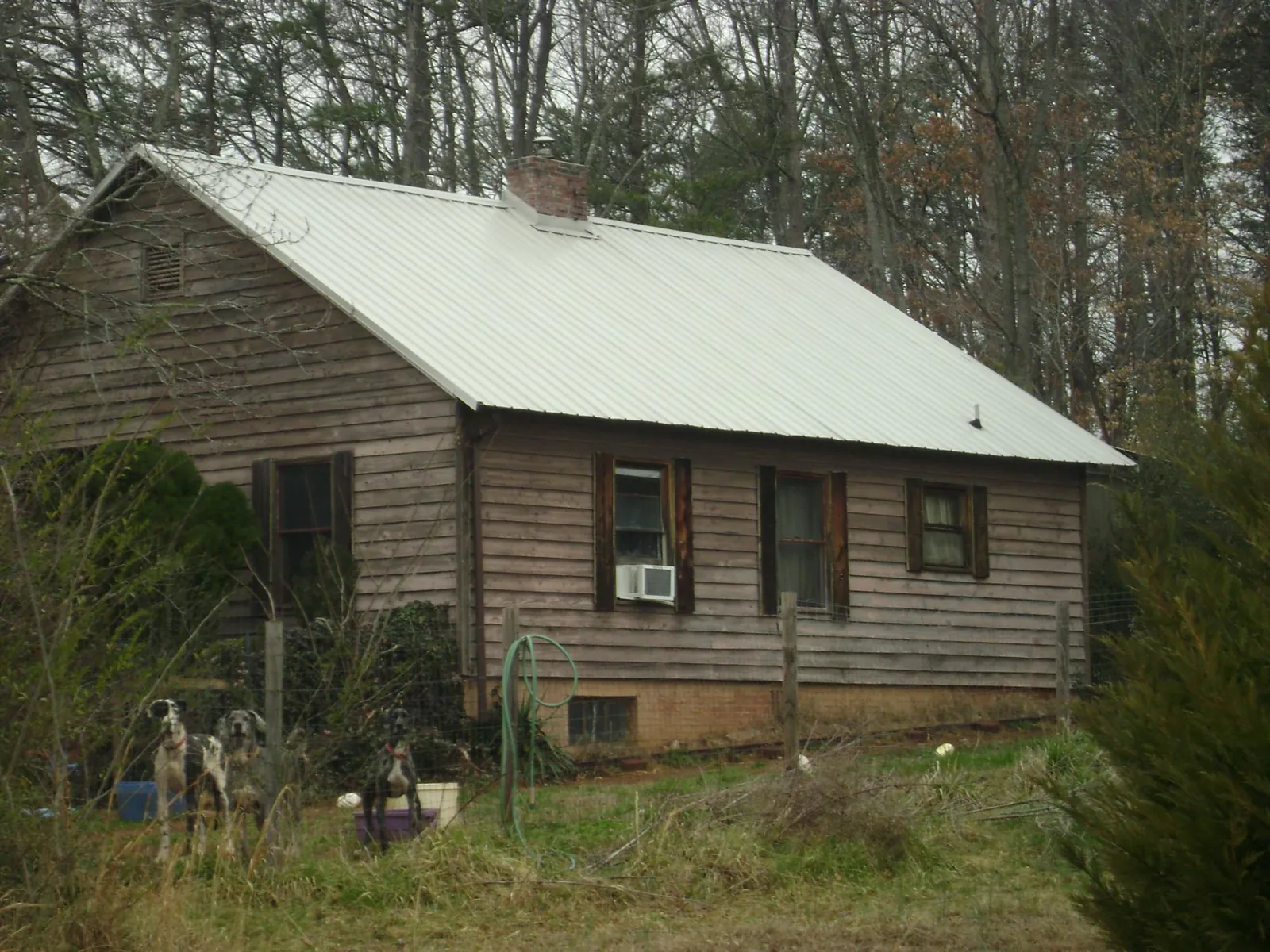 White metal roof on an old wood sided farmhouse, from a Metal Roof Installation job in Etters